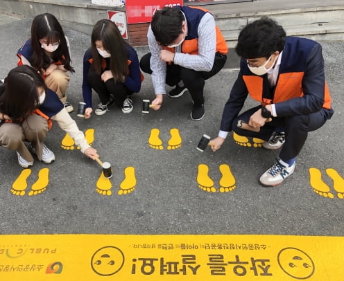 13일 소상공인시장진흥공단 직원들이 대전 중리동 일대 어린이보호구역 횡단보도 앞에서 ‘노란 발자국’을 설치하고 있다. 