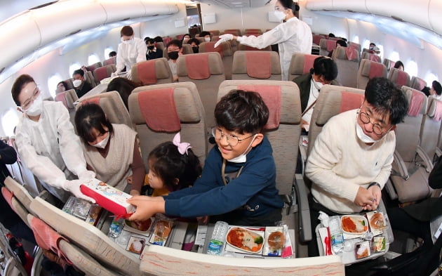 24일 출발한 아시아나항공 'A380 한반도 일주 비행' 항공기에 탑승한 한 가족승객이 이륙 후 기내식 서비스가 시작되자 즐거운 표정으로 점심식사를 즐기고 있다. 영종도=공항사진기자단.