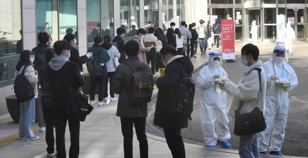  25일 서울 광진구 세종대학교에서 열린 SK그룹 하반기 공채 필기전형인 'SK종합역량검사(SKCT)'에서 수험생들이 일회용 장갑을 받으며 고사장에 입실하고 있다./김범준기자 bjk07@hankyung.com