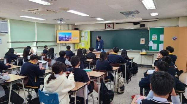 포스코건설 직원이 지난 20일 인천 옥련중학교 학생들에게 회사가 건설한 대표 건축물을 소개하고 건설업분야에 대한 교육을 실시하고 있다. 포스코건설
