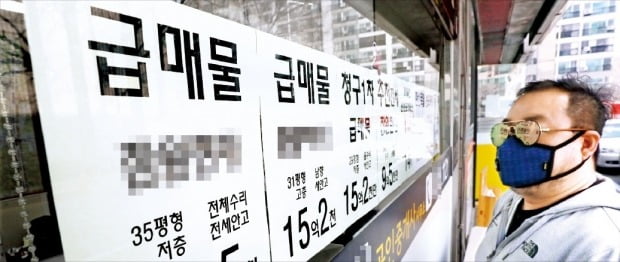 서울 강남의 한 부동산 중개업소 앞에서 시민이 급매 게시물을 살펴보고 있다.  /연합뉴스 