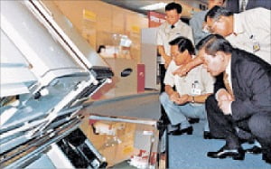 < 냉장고 앞에 쪼그려 앉은 이건희 회장 > 이건희 회장이 1995년 삼성전자 광주공장에서 생산된 냉장고를 살펴보고 있다.  /한경DB 