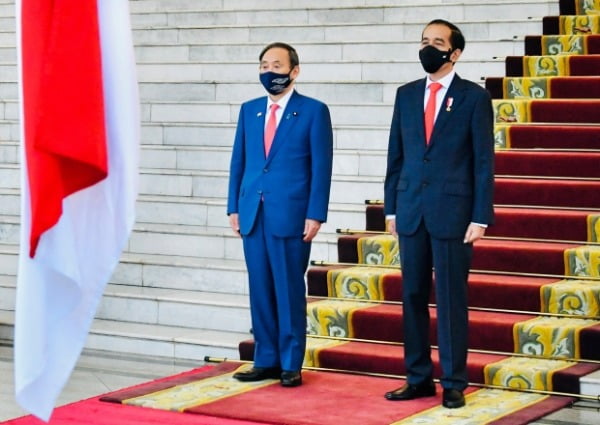 20일(현지시간) 인도네시아를 방문한 스가 요시히데(왼쪽) 일본 총리가 수도 자카르타 외곽 보고르 대통령궁에서 열린 환영식에서 조코 위도도 인도네시아 대통령과 함께 나란히 서서 양국 국가 연주를 듣고 있다. /사진=연합뉴스