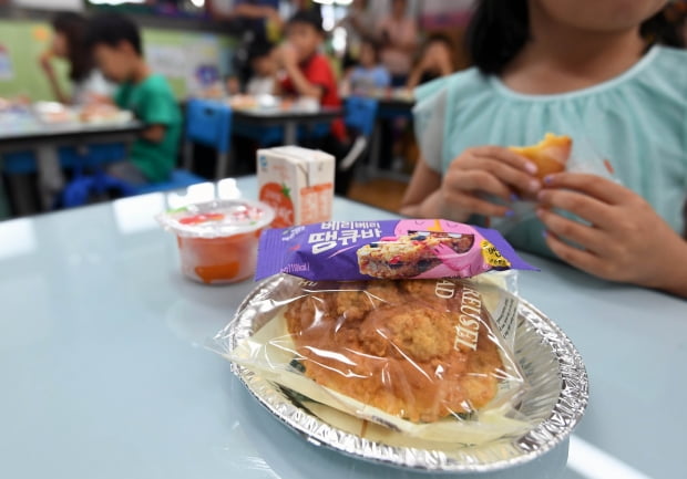 지난해 7월 학교 비정규직 노동자들이 총파업에 들어가면서 서울의 한 초등학교에서 어린이들이 대체 급식으로 제공된 빵과 에너지바 등으로 점심식사를 하고 있다. 사진=연합뉴스