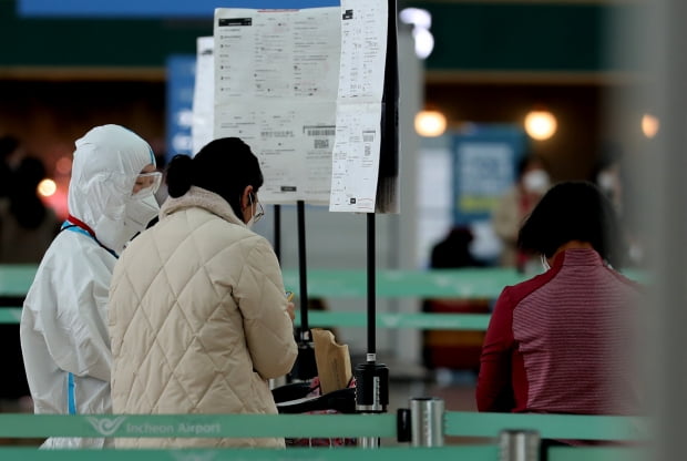 12일 오후 인천국제공항에서 승객들이 신종 코로나바이러스 감염증(코로나19) 음성확인서를 두 장을 공항 관계자에게 보여주고 있는 모습. 뉴스1