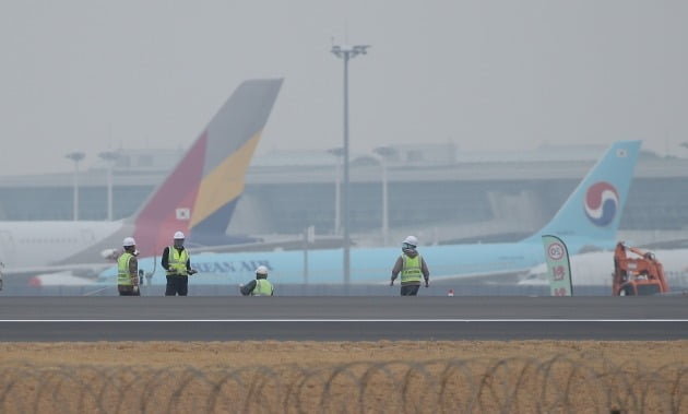 대한항공의 아시아나항공 인수 발표가 하루 지난 17일 오후 인천국제공항 제4활주로 공사현장 뒤로 대한항공과 아시아나항공 여객기들이 세워져 있다. 2020.11.17 [사진=연합뉴스]