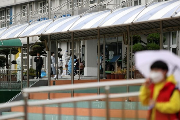 18일 오후 광주 서구 한 초등학교에 임시 선별진료소가 설치돼 학생이 신종 코로나바이러스 감염증(코로나19) 진단검사를 받고 있다. 이 학교 재학생이 코로나19 양성 판정을 받으면서 전교생과 교직원 전수 검사가 이뤄졌다. 2020.11.18 [사진=연합뉴스]