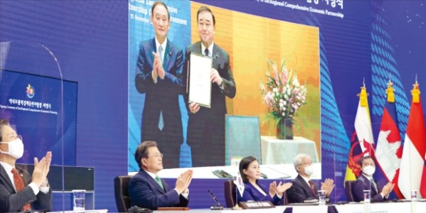 문재인 대통령이 15일 청와대에서 화상으로 열린 ‘역내포괄적경제동반자협정(RCEP) 정상회의 및 협정 서명식’에 참석해 일본의 서명식을 본 뒤 박수를 치고 있다. 문 대통령 뒤 모니터를 통해 스가 요시히데 일본 총리(왼쪽)가 박수치는 모습도 보인다. 허문찬 기자 sweat@hankyung.com 