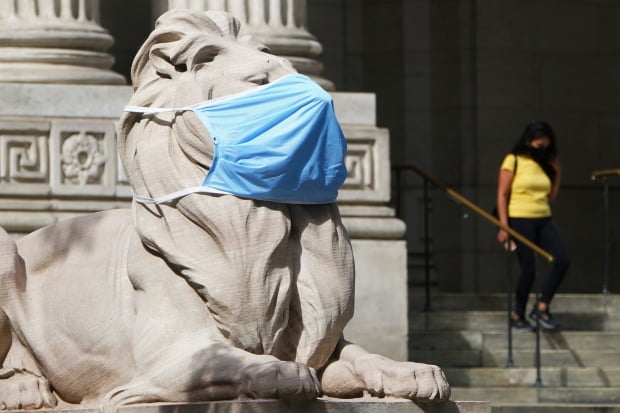 미국 뉴욕 맨해튼의 공립 도서관 앞 사자상에 신종 코로나바이러스 감염증(코로나19)에 대한 경각심을 불러일으키기 위해 대형 마스크가 씌워져 있다./사진=연합뉴스