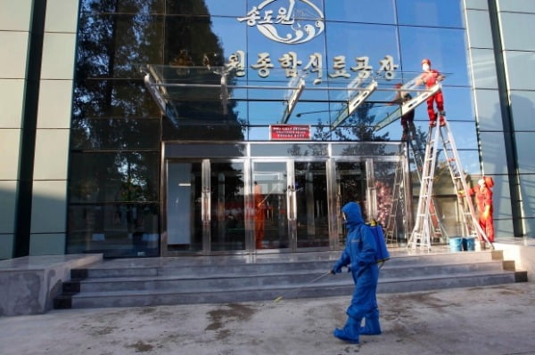 북한 강원도 원산에 있는 송도원종합식료공장 입구에서 지난달 28일 한 방역 관계자가 신종 코로나바이러스 감염증(코로나19) 예방을 위해 분무기를 메고 주변을 소독하고 있다. /사진=연합뉴스