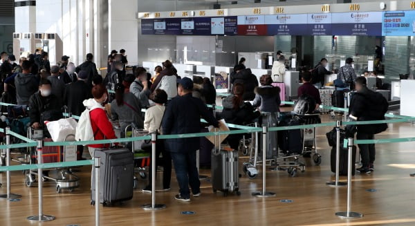 지난 12일 오후 인천국제공항 1터미널 출국장 중국 항공기 체크인카운터에서 승객들이 신종 코로나바이러스 감염증(코로나19)에 걸리지 않았다는 것을 증명하는 음성확인서를 두 장을 공항 관계자에게 보여주고 있다/사진=뉴스1