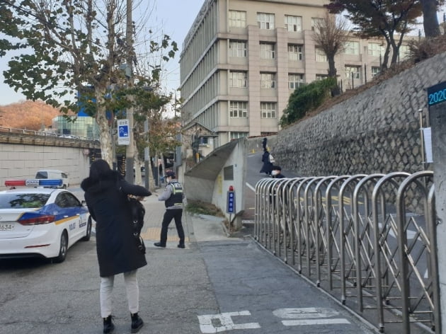 3일 오전 8시 10분께 서울 서대문구 이대부고에서 한 수험생이 경찰차에서 내려 급하게 시험장으로 향하고 있다.  김남영 기자