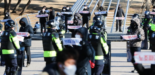 민주노총 관계자가 4일 서울 여의도공원에서 전태일 3법 통과를 촉구하는 피켓시위를 벌이며 경찰과 대치하고 있다.  이날 경찰은 서울시의 신종 코로나바이러스 감염증(코로나19) 감염 우려에 따른 집회 금지 조치에 따라 민주노총의 산발적인 집회에 대비해 국회 주변에 차벽을 세웠다.  뉴스1