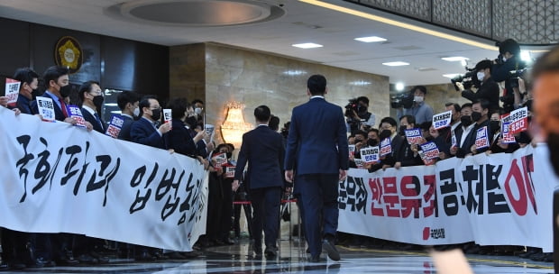 국민의힘 의원들이 10일 여의도 국회 본회의장 입구에서 본회의에 입장하는 더불어민주당 의원들을 향해 