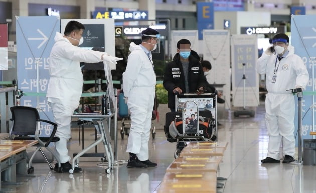 영국발 변이 코로나19 바이러스가 국내에서 확인되는 등 코로나19 확산이 계속되고 있는 28일 오전 인천국제공항 1터미널 입국장에서 방호복을 착용한 관계자들이 해외입국객을 안내하고 있다. 2020.12.28 [사진=연합뉴스]