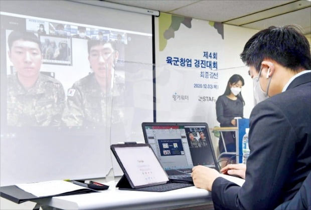 육군인사사령관상을 받은 국방부 근무지원대 Ambient팀의 이철민 상병과 조준혁 상병이 아동·치매 환자 실종 방지 생체이식칩 아이템을 설명하고 있다.   김영우 기자 youngwoo@hankyung.com 