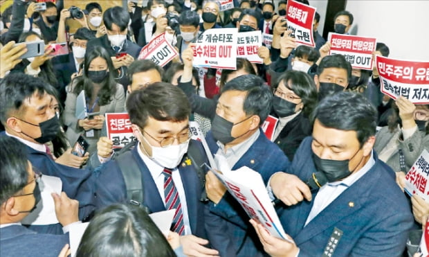 더불어민주당 김남국 의원이 7일 법사위 회의실 앞에서 고위공직자범죄수사처법 처리에 반대해 시위를 하고 있는 국민의힘 의원들을 뚫고 회의장으로 들어가고 있다.  국회사진기자단 