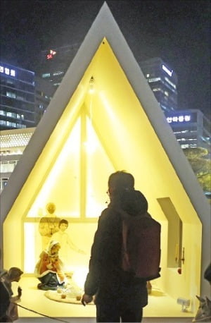 24일 밤 서울 명동대성당을 찾은 한 시민이 말구유를 살펴보고 있다.  /연합뉴스 