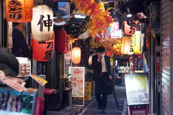 일본 도쿄에서 마스크를 착용한 한 남성이 뒷골목 술집 거리를 따라 홀로 걸어가고 있다. /사진=AP