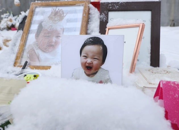  13일 오전 경기도 양평군 하이패밀리 안데르센 공원묘원에 양부모의 학대로 생후 16개월 만에 숨진 정인 양의 사진이 놓여있다. [사진=연합뉴스]