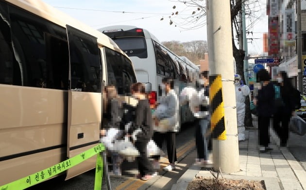 지난 25일 오후 대전시 중구 대흥동 IEM국제학교에서 신종 코로나바이러스 감염증(코로나19) 확진자들이 치료센터로 이동하기 위해 차량에 탑승하고 있다. [사진=연합뉴스]