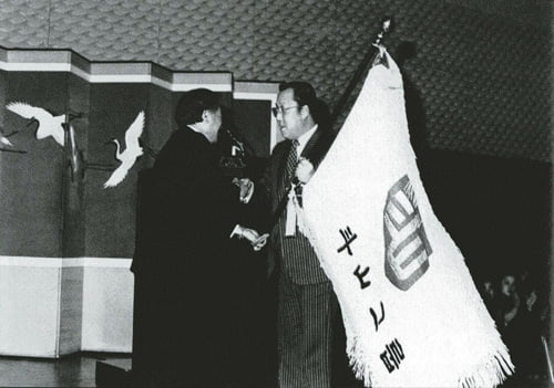 1981년 두산그룹 회장 이취임식에서 정수창 회장으로부터 두산그룹기를 전달받고 있는 박용곤 회장.