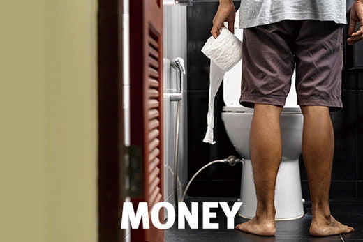 Man holding tissue roll in toilet of his house