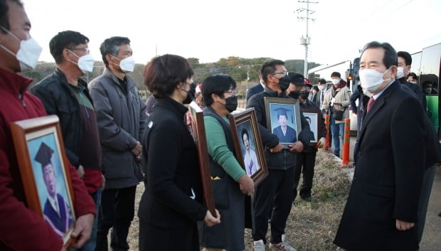 지난해 11월 정세균 국무총리가 '암 집단 발병'이 확인된 전북 익산 장점마을을 방문해 희생자의 영정사진을 든 주민들을 위로하고 있다. /사진=연합뉴스