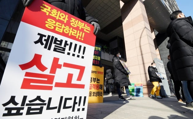 2일 오전 서울 중구 LW컨벤션에서 '사회적 거리두기 단계 개편을 위한 공개토론회'가 열렸다. 토론회장 앞에서 1인 시위에 나선 자영업자들이 방역지침 끝장토론, 영업시간 연장 등을 촉구하고 있다.  허문찬기자 sweat@hankyung.com