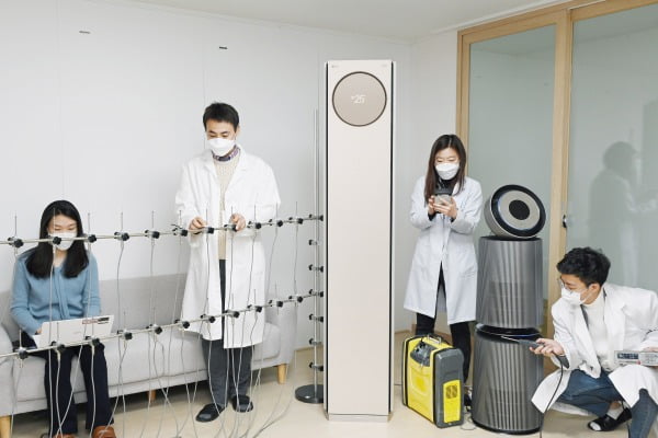 LG전자 연구원들이 서울 금천구 가산R&D캠퍼스에 위치한 공기과학연구소에서 휘센 타워 에어컨의 기류(氣流), 퓨리케어 360˚ 공기청정기 알파의 미세먼지제거능력 등을 시험하고 있다/사진제공=LG전자