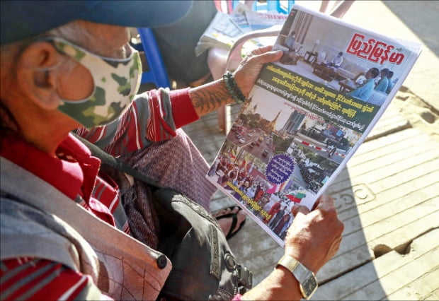 2일 미얀마 양곤에서 한 남성이 ‘대통령 대행이 군부에 권력을 이양했다’고 적힌 신문을 보고 있다. AP연합뉴스 