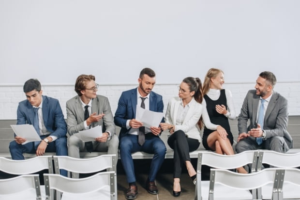 businesspeople sitting with documents on stage and talking in hub