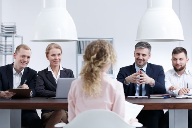 Young woman sitting in front of staff on job interview