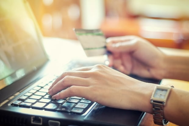 woman asian using laptop and credit card shopping online , selective focus on hand,soft focus and vintage tone