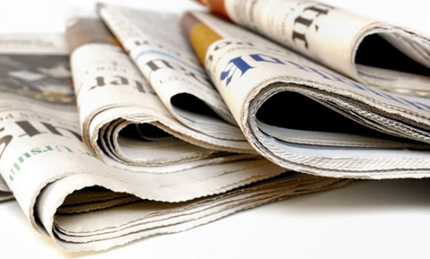 Stack of international newspapers on white background