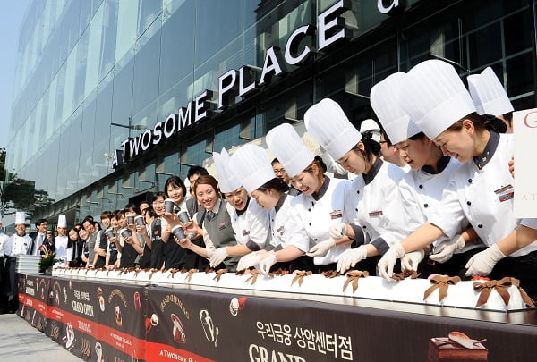 CJ푸드빌이 운영하는 투썸플레이스는 18일 서울 우리금융상암센터점에서 100호점 오픈 행사를 갖고 대형케이크를 만들어 나눠주는 행사를 가졌다.
/강은구기자 egkang@hankyung.com 2010.10.18    