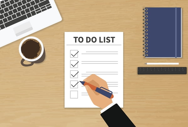 Businessman sitting at his desktop and fulfilling his work checklist