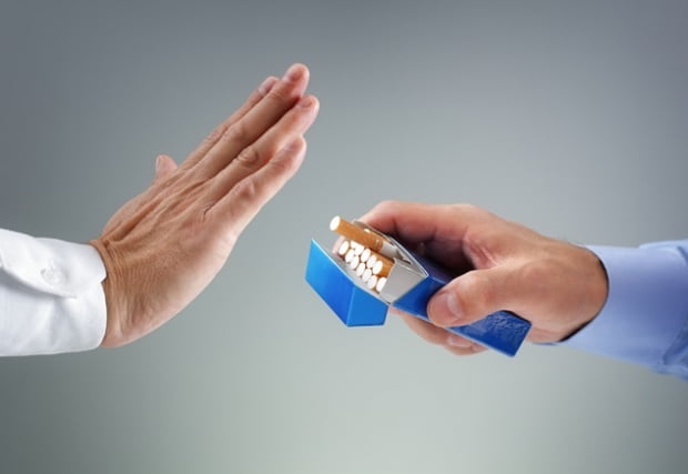 Man refusing a cigarette from a pack of smokes concept for quitting smoking and healthy lifestyle