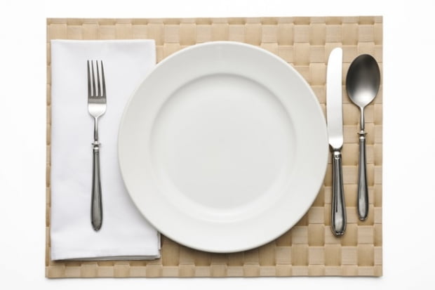 Place setting on brown place mat isolated on a white background with clipping path.