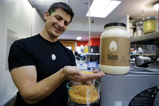 In this photo taken Tuesday, Dec. 3, 2013, CEO Josh Tetrick holds a species of yellow pea used to make Just Mayo, a plant-based mayonnaise, at Hampton Creek Foods in San Francisco. Can plants replace eggs? A San Francisco startup backed by Bill Gates believes they can. Hampton Creek Foods is scouring the planet for plants that can replace chicken eggs in everything from cookies to omelets to French toast. Funded by prominent Silicon Valley investors, the upstart seeks to disrupt a global egg industry that backers say wastes energy, pollutes the environment, causes disease outbreaks and confines chickens to tiny spaces. (AP Photo/Eric Risberg)
