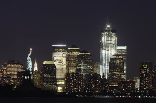 In this Aug. 23, 2011 file photo, One World Trade Center rises above the Manhattan skyline and the Statue of Liberty, in New York. The tower will be 104 floors and 1,776 feet (541 meters) tall when completed. Ten years after terrorists destroyed the World Trade Center, the new World Trade Center is rising from ground zero. (AP Photo/Mark Lennihan, File)