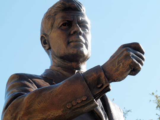 A bronze statue of President John F. Kennedy stands in downtown Fort Worth as part of the JFK Tribute that was dedicated Thursday, Nov. 8, 2012, in Fort Worth, Texas. The exhibit that includes a granite wall with photographs and Kennedy’s quotes is  near the site where he gave one of his last two public speeches the morning of Nov. 22, 1963, before he was assassinated hours later in nearby Dallas. (AP Photo/Angela K. Brown)