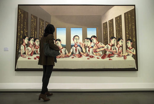 epa03913808 A visitor looks at a work of art entitled  'The last supper' displayed as part of the retrospective exhibition of Chinese painter Zeng Fanzhi in the Museum of Modern Art in Paris, France, 17 October 2013.The exhibition runs from 18 October to 16 February 2014.  EPA/IAN LANGSDON