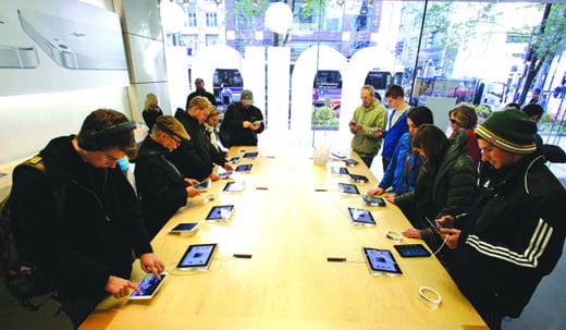 FILE - In this Friday, Nov. 2, 2012 file photo, Shoppers check out the new Apple iPad mini at the Apple store on Michigan Ave. in Chicago. Apple said Monday, Nov. 5, 2012,  it sold 3 million iPads of all kinds in the first three days it sold the new Mini model. (AP Photo/M. Spencer Green, FIle)