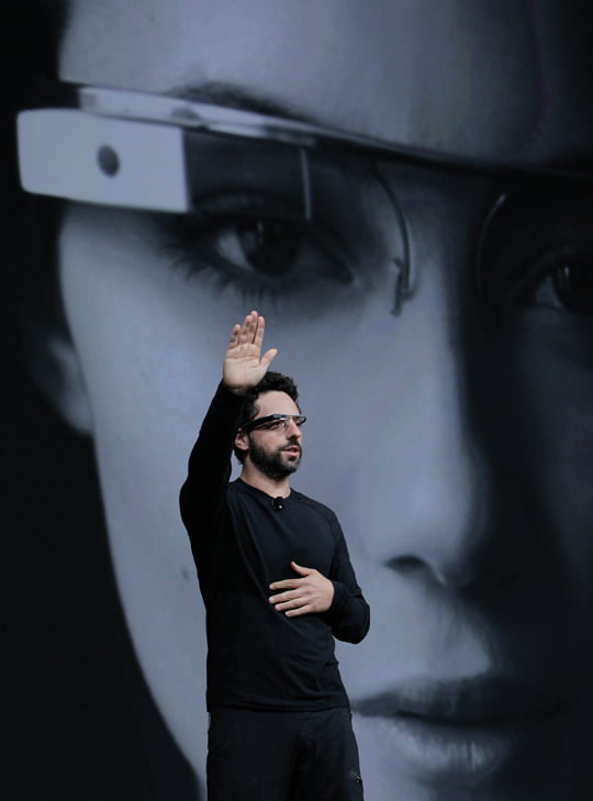 Google co-founder Sergey Brin demonstrates Google's new Glass, wearable internet glasses, at the Google I/O conference in San Francisco, Wednesday, June 27, 2012.  The audience got live video feeds from their glasses as they descended to land on the roof of the Moscone Center, the location of the conference. (AP Photo/Paul Sakuma)