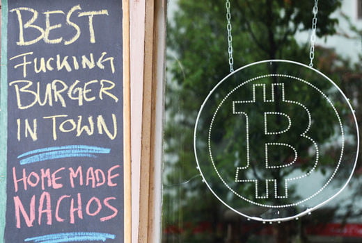 The logo of the new virtual currency Bitcoin hangs in the window of restaurant room 77 in Berlin-Kreuzberg,�Germany, 24 May 2013. More and more business are accepting the virtual currency Bitcoins. Photo: Jens�Kalaene