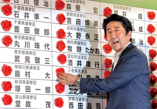 <YONHAP PHOTO-0036> Japan's Prime Minister and President of the Liberal Democratic Party (LDP), Shinzo Abe smiles as he places a red paper rose on a LDP candidate's name to indicate an election victory at the party's headquarters in Tokyo on July 21, 2013. The coalition of Japan's Prime Minister Shinzo Abe won a resounding victory in upper house elections.  AFP PHOTO / KAZUHIRO NOGI../2013-07-22 00:57:03/
<????沅??? ?? 1980-2013 ???고?⑸?댁?? 臾대? ??? ?щ같? 湲?吏?.>