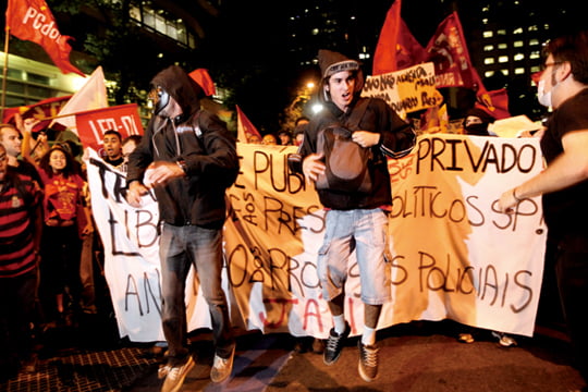 People protest the increase in bus and subway fares in Rio de Janeiro, Thursday, Brazil, June 13, 2013. Thousands of protesters are taking to the streets in Brazil's two biggest cities, protesting against 10-cent hikes in bus and subway fares. (AP Photo/Silvia Izquierdo)