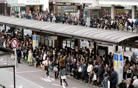 CORRECT COUNTRY CODE IN HEADER FIELD - Commuters wait in a long queue at a bus terminal outside Yokohama railway station in Yokohama, southwest of Tokyo, following a strong earthquake hit eastern Japan on Friday, March 11, 2011. (AP Photo/Shuji Kajiyama)