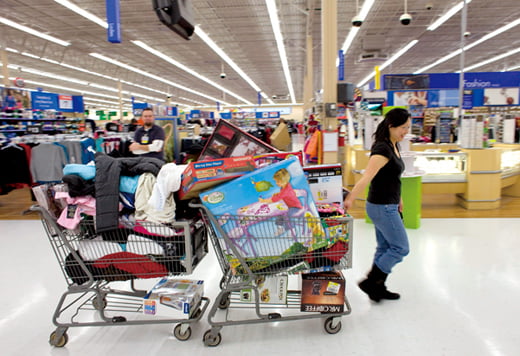Jennifer Yen, who has so much things she needs 2 carts, wheels around during Black Friday shopping inside a Wal-Mart Supercenter in Denver, Colorado, U.S., on Friday, Nov. 27, 2009. 
 Photographer: Matthew   Staver/Bloomberg